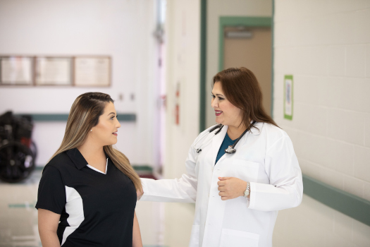 Two female Medical Professionals smiling at each other