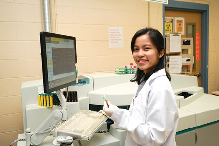 Female Lab worker touching a monitor in front of her